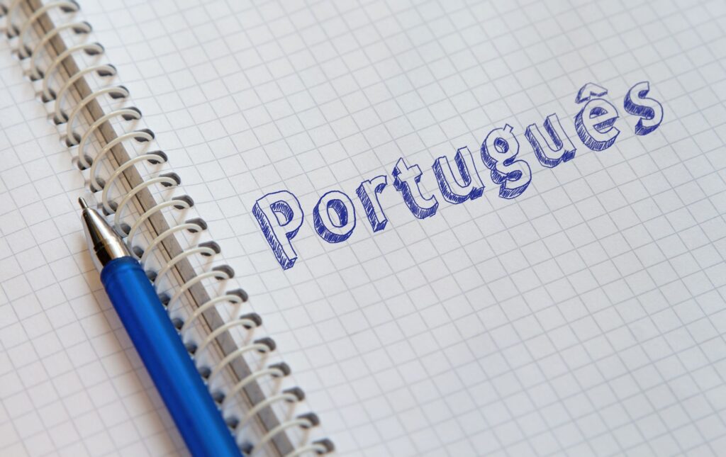 Imagem de caderno com a palavra 'Português' escrita à mão, ilustrando a importância da escrita no aprendizado da língua.