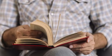Pessoa sentada lendo um livro, representando a importância da leitura.