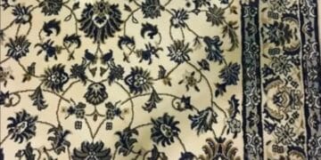 Desafio lógico com um celular camuflado sobre tapete floral ao lado de uma mesa branca.