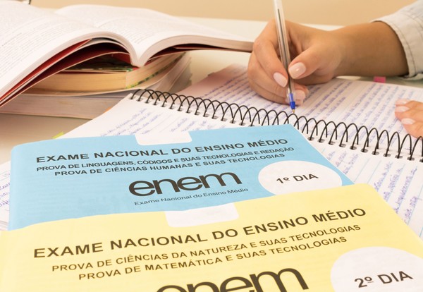 Imagem de material de estudo para o ENEM, com cadernos e livros abertos, mostrando provas do exame. A data para inscrições do Enem já passou.