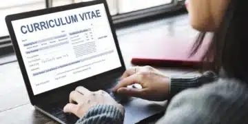 Pessoa preenchendo um currículo em um notebook, representando oportunidades para melhorar a carreira.