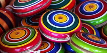 Ioiôs coloridos com círculos concêntricos, brinquedos tradicionais que geram nostalgia.