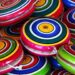 Ioiôs coloridos com círculos concêntricos, brinquedos tradicionais que geram nostalgia.