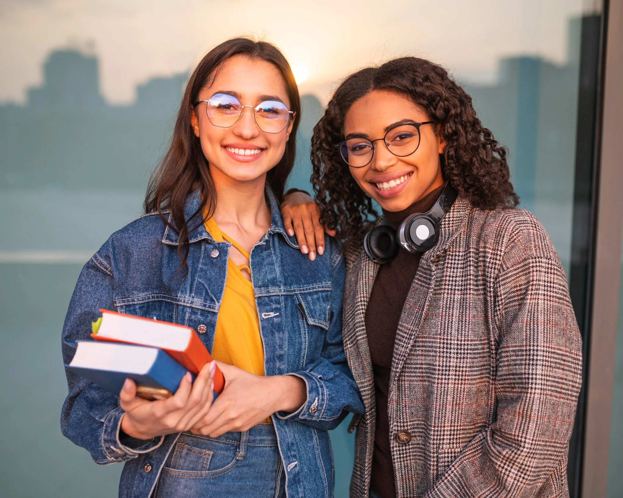 Dois estudantes sorrindo enquanto seguram livros, representando os desafios e as verdades enfrentadas por todos os estudantes