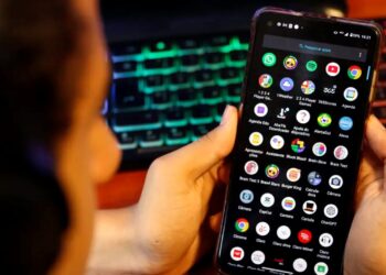 Uma pessoa mexendo no celular e acessando aplicativos, que pode ser interpretado como um jovem utilizando a internet, para ilustrar o debate sobre a exposição online de crianças e adolescentes.