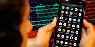 Uma pessoa mexendo no celular e acessando aplicativos, que pode ser interpretado como um jovem utilizando a internet, para ilustrar o debate sobre a exposição online de crianças e adolescentes.
