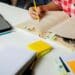 Estudante preparando-se para o Enem, com livros, cadernos e materiais de organização de estudos sobre a mesa.