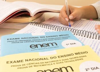 Pessoa estudando para o ENEM 2025, com livros abertos, provas do ENEM e caderno de anotações.