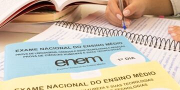 Pessoa estudando para o ENEM 2025, com livros abertos, provas do ENEM e caderno de anotações.