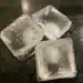 Cubos de gelo flutuando em um copo de água, com destaque para a curiosidade de como o gelo não afunda devido à sua menor densidade.