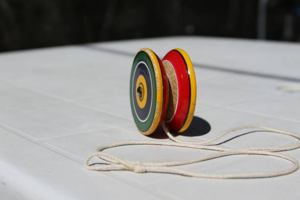 Ioiô colorido sobre uma superfície branca, com círculos concêntricos nas cores verde, amarelo, vermelho e preto.