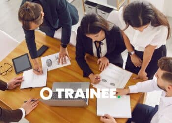 Grupo de profissionais em reunião de negócios, discutindo gráficos e relatórios com foco em programas de trainee