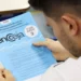 Participante do Exame Nacional para Certificação de Competências de Jovens e Adultos (Encceja) 2025 lendo as questões de Ciências Humanas e suas Tecnologias.