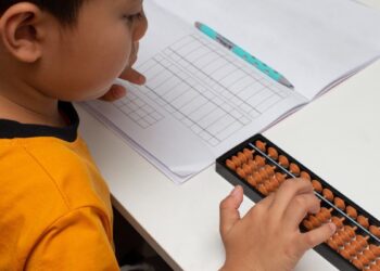 Criança utilizando o ábaco para aprender matemática.