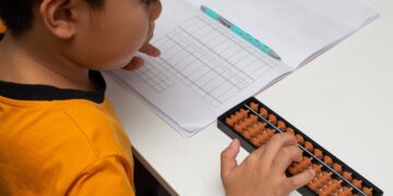 Criança utilizando o ábaco para aprender matemática.