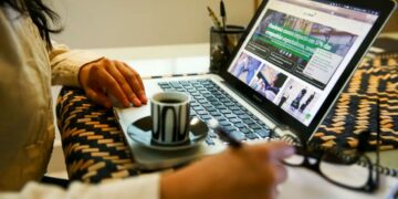 essoa trabalhando em home office (trabalho remoto) com notebook e café