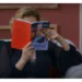 Cena da atriz Beatriz Segall, como a personagem Odete Roitman, segurando o livro "O Perigo de Estar Lúcida" em frente ao rosto.