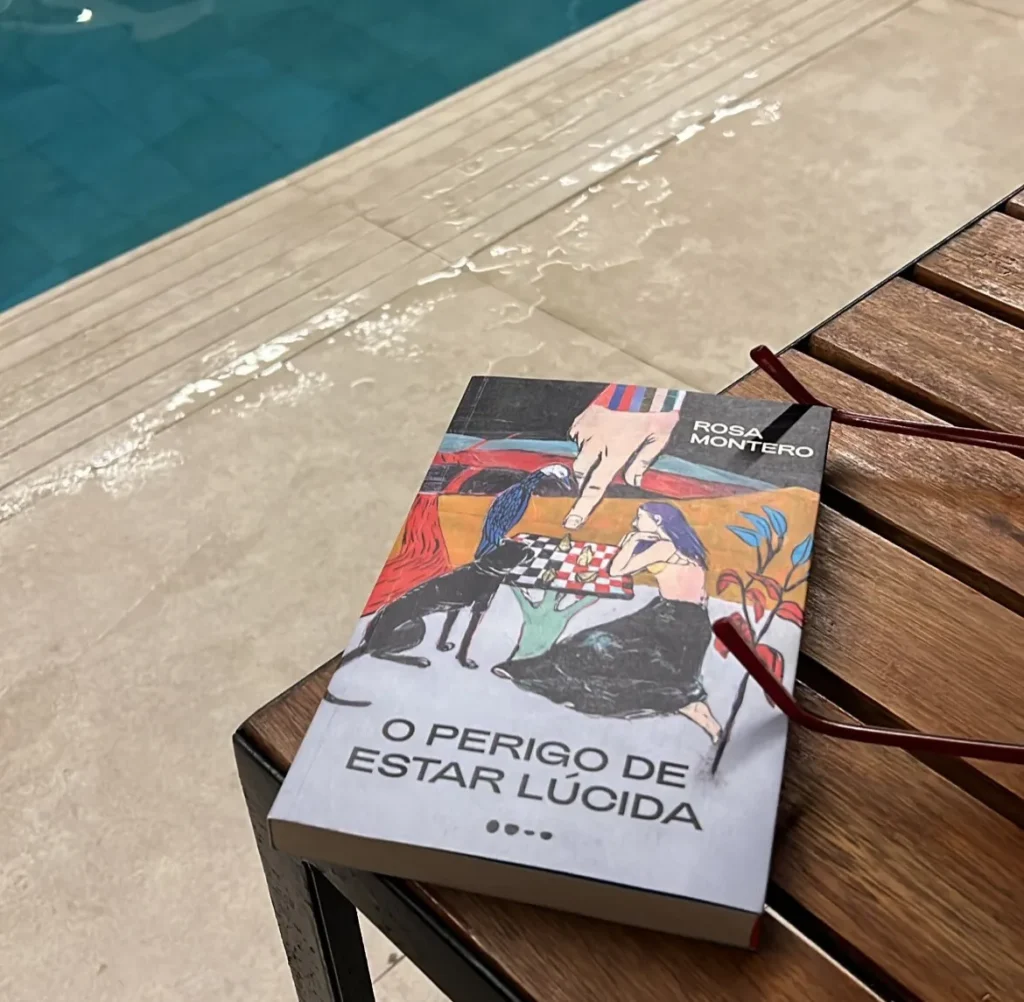 Capa do livro "O Perigo de Estar Lúcida", de Rosa Montero, com uma ilustração abstrata e colorida, que combina figuras humanas, animais e objetos.