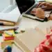 Pessoa estudando e trabalhando ao mesmo tempo, com livros e computador em uma mesa organizada, representando o equilíbrio entre estudo, trabalho e tempo pessoal