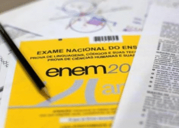 Caderno de questões do ENEM 2025 com um lápis e folhas de rascunho em uma mesa, representando a preparação para a prova.