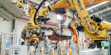 Robôs industriais em uma linha de montagem de veículos, representando as profissões que estarão em alta.