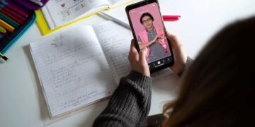 Estudante assiste aula no TikTok enquanto revisa anotações para o Enem.