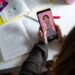 Estudante assiste aula no TikTok enquanto revisa anotações para o Enem.