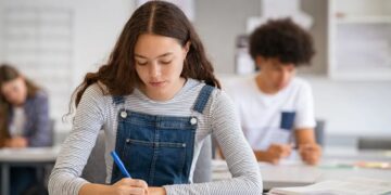Imagem ilustrativa de estudante escrevendo concentrada durante simulado de redação.