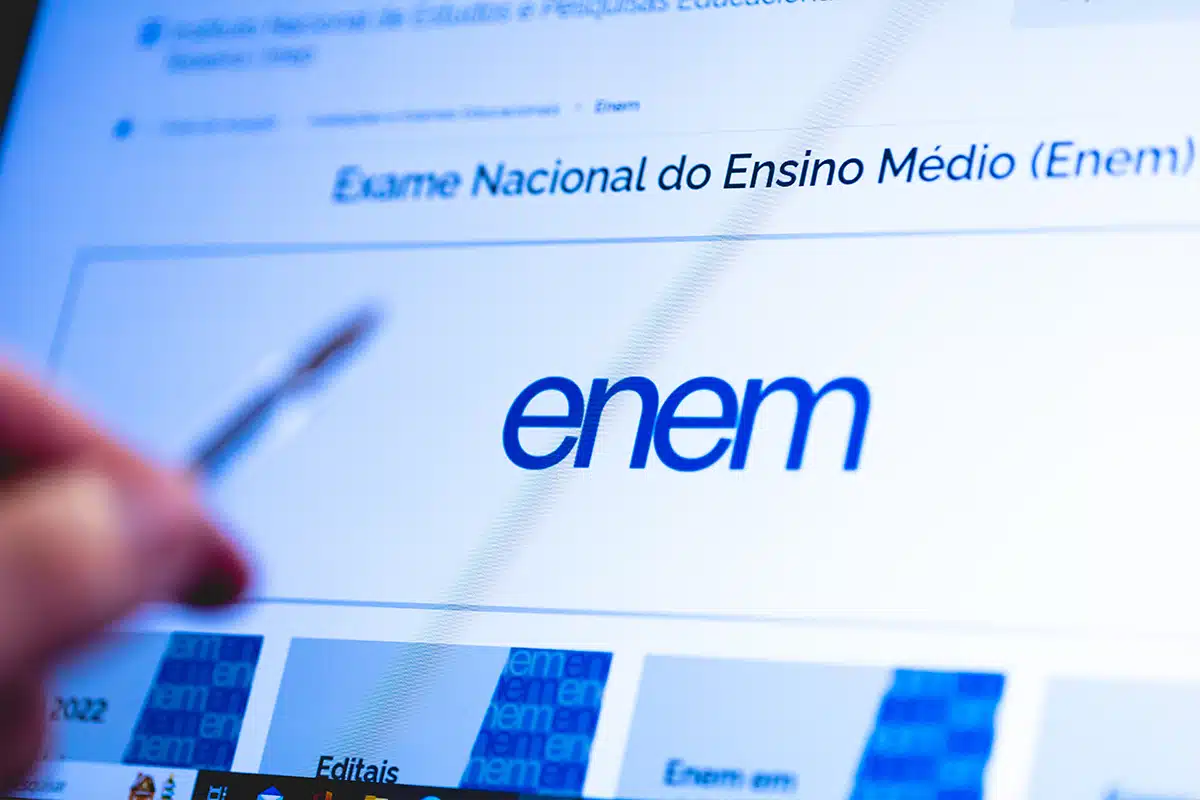 Página oficial do ENEM 2022 do Inep Tela de computador mostrando pagina oficial do Exame Nacional do Ensino Médio ENEM 2022 do Inep com mão segurando caneta