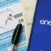 Imagem de materiais do Enem 2025, incluindo uma capa do caderno de questões, caneta e smartphone com o logotipo do Enem.
