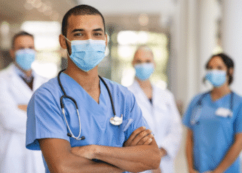 Estudantes e profissionais de medicina com jaleco e máscara de proteção.