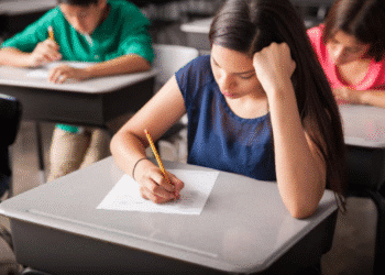 Estudantes fazendo prova em sala de aula.