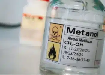 Garrafa de metanol com rótulo de advertência de toxicidade, com imagens de perigo (morte e inflamabilidade).