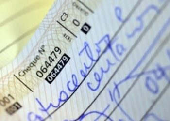 Detalhe de cheque manuscrito com valor preenchido por extenso, prática comum para evitar fraudes