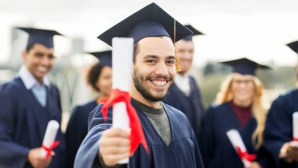 Jovem graduado sorrindo com diploma em mãos, simbolizando a conquista acadêmica e a decisão profissional do curso escolhido.
