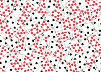 Desafio visual com muitas cartas de baralho com naipes de copas e espadas espalhadas sobre uma superfície branca.