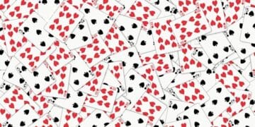 Desafio visual com muitas cartas de baralho com naipes de copas e espadas espalhadas sobre uma superfície branca.