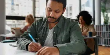 Homem estudando em ambiente tranquilo, com foco no processo de aprendizado, para entender como se preparar para a prova do PND.