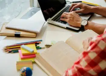 Estudante estudando com materiais educativos, representando o impacto da alimentação na concentração durante a preparação para vestibulares e Enem