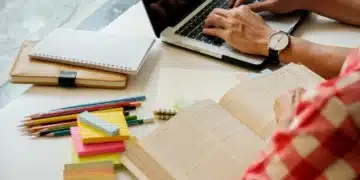 Estudante estudando com materiais educativos, representando o impacto da alimentação na concentração durante a preparação para vestibulares e Enem
