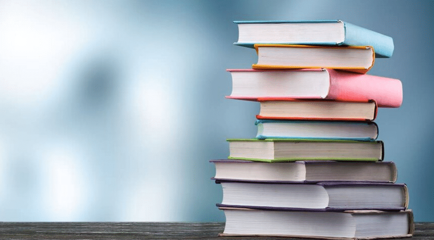 Pilha de livros coloridos empilhados sobre uma mesa.