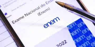 Tela de celular aberta no site oficial do Exame Nacional do Ensino Médio (Enem) com uma caneta, representando a consulta de notas e resultados para treineiros.