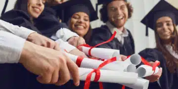 Formandos em comemoração seguram seus certificados, simbolizando o diploma de curso técnico e a entrada no mercado de trabalho.