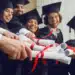 Formandos em comemoração seguram seus certificados, simbolizando o diploma de curso técnico e a entrada no mercado de trabalho.