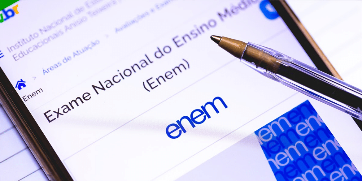 Página oficial do ENEM aberta em um celular, com uma caneta posicionada sobre a tela.