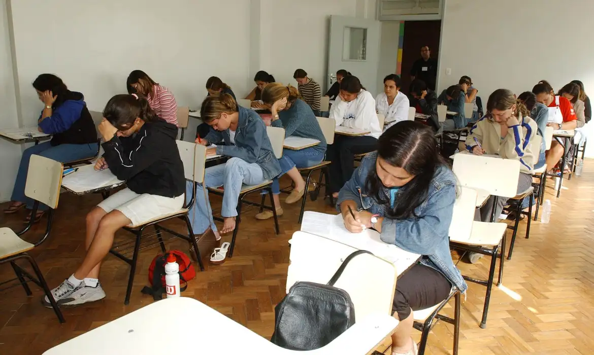 Alunos jovens fazendo prova em sala de aula Alunos jovens fazendo prova em sala de aula