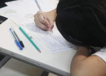 Estudante do Ensino Médio durante a prova do Provão Paulista, com foco nas questões do exame.