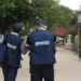 Dois agentes do IBGE caminhando por rua de bairro durante coleta de dados para pesquisa
