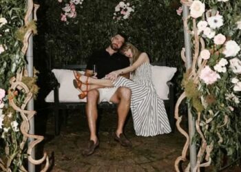 Taylor Swift e Travis Kelce abraçados em banco, ilustrando a intensa conexão e a afinidade que fãs sentem com celebridades em relações parassociais.