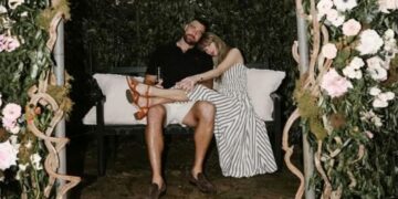 Taylor Swift e Travis Kelce abraçados em banco, ilustrando a intensa conexão e a afinidade que fãs sentem com celebridades em relações parassociais.